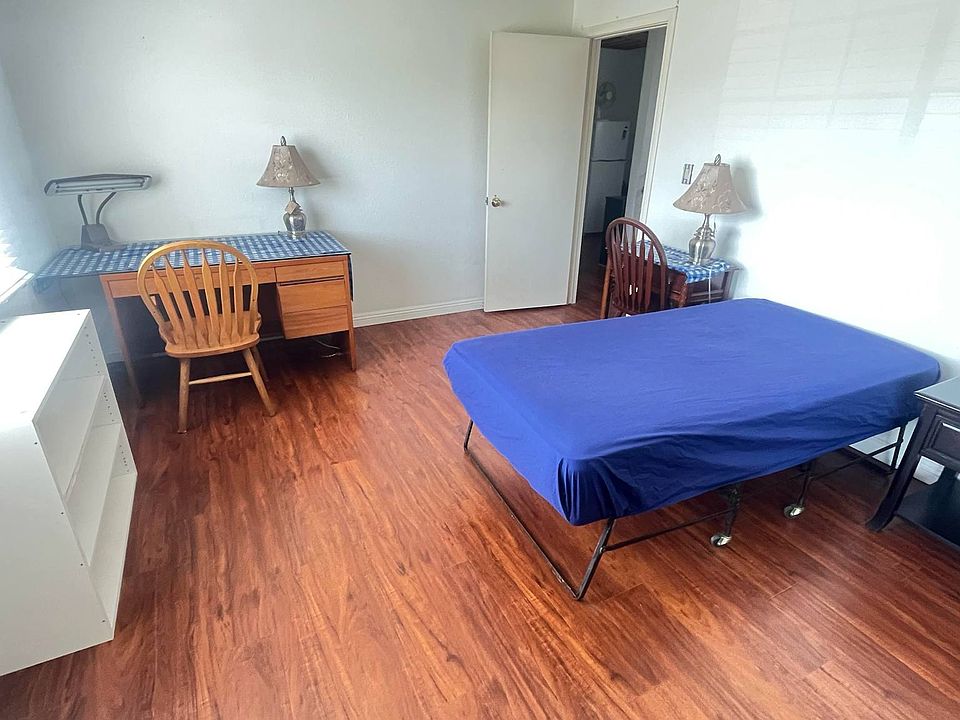 Large furnished room with desk, bookcase, twin size bed, night stand, and large closet. Wood flooring.