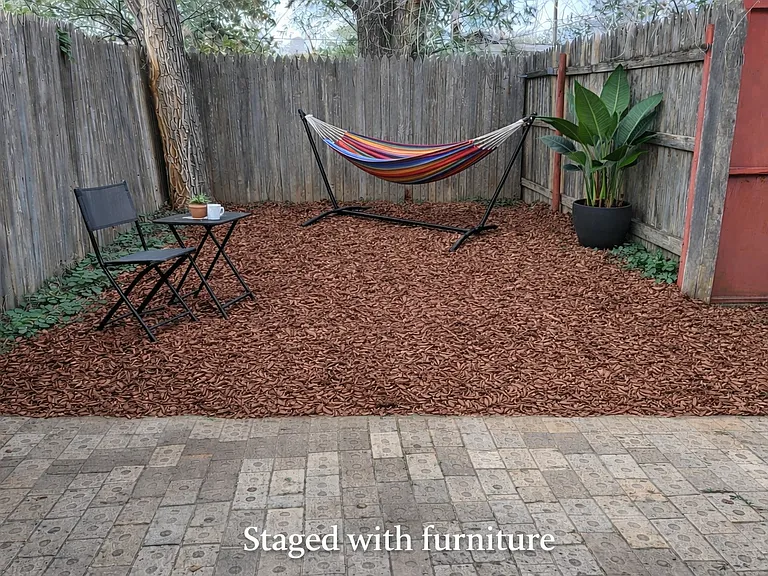Small privacy fenced yard with room for garden or enjoying the outdoors under large trees
