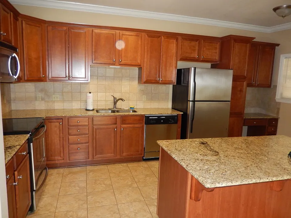 Large beautiful designer kitchen with cherry cabinets, grani