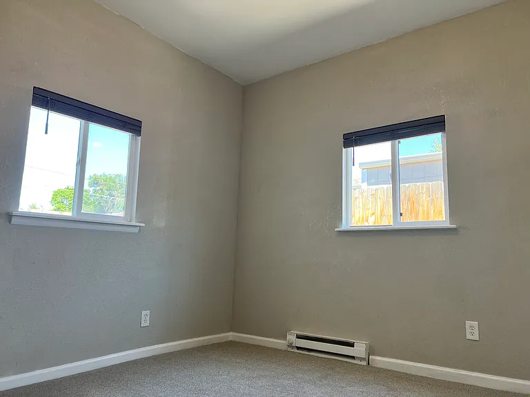 Private 3rd bed/office with soaring high ceilings, new carpet, fresh paint, ceiling fan, and included portable AC unit.