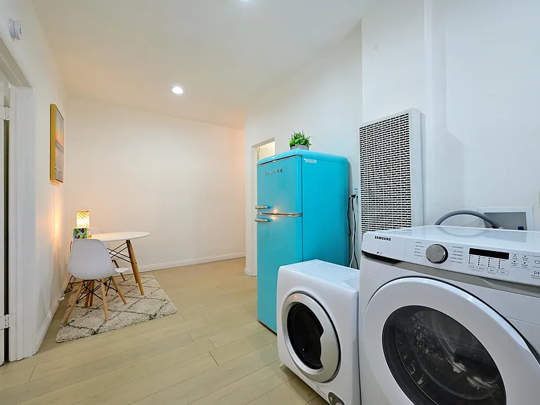 Fully furnished living room with upgraded kitchen, appliances, and laundry machines