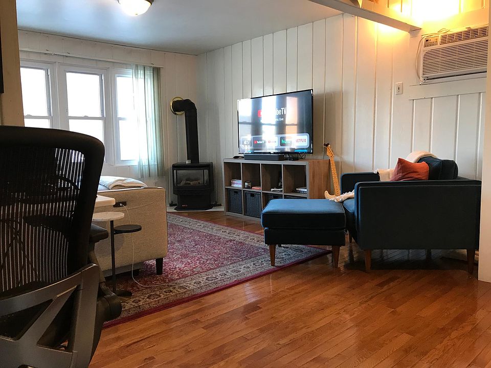 Gas fireplace and wall AC unit in living room.