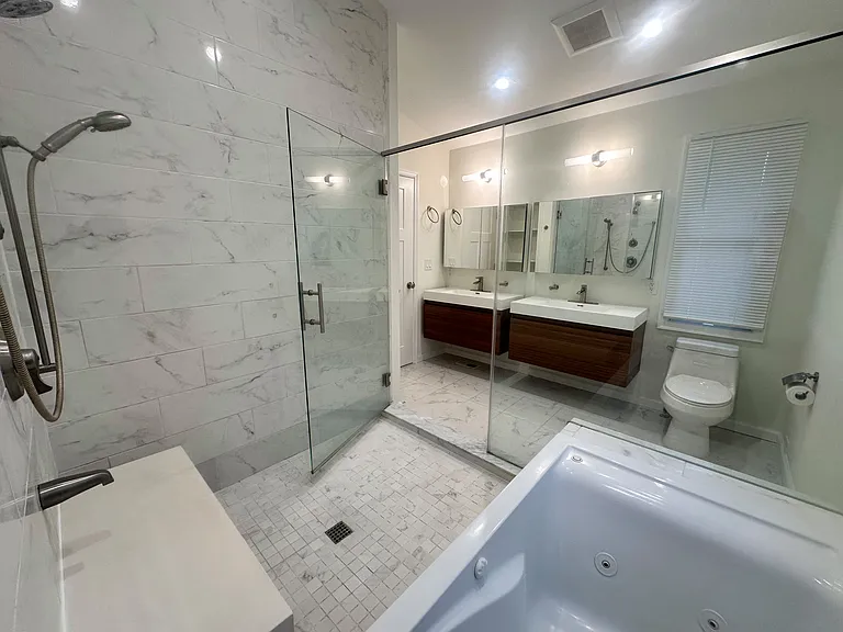 Primary bathroom features two vanities with plenty of drawer and mirror storage, a linen closet, separate shower and large tub. Three windows and cathedral ceiling.