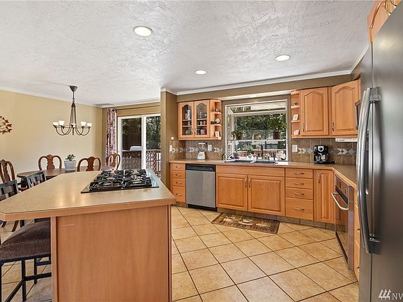 Open, free flowing kitchen. Ideal for entertaining and enjoyment. Newer fridge, custom tile backsplash, garden window.