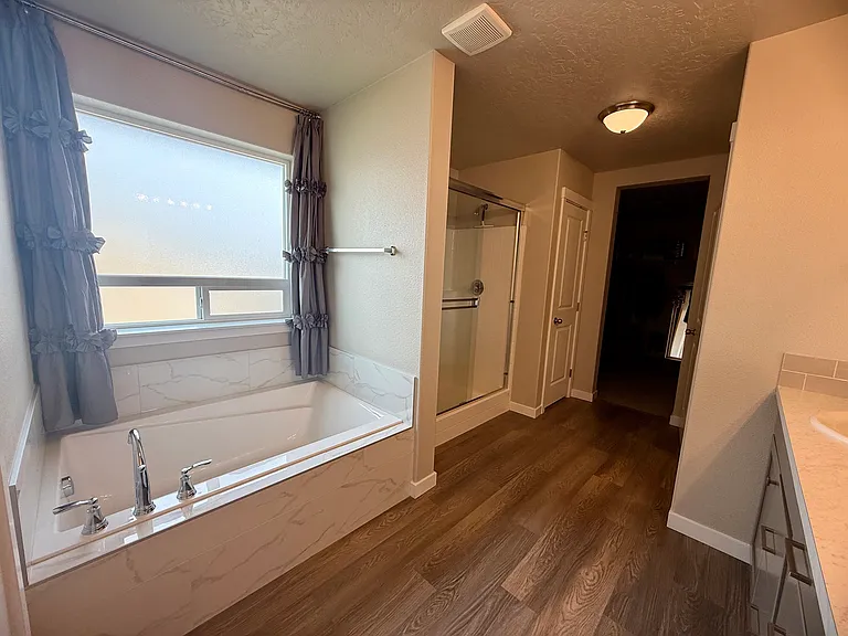 Primary bathroom with soaking tub under the window and a separate walk-in shower.