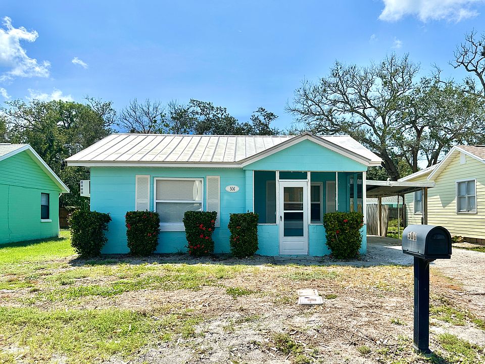 Front of house with single carport and driveway.