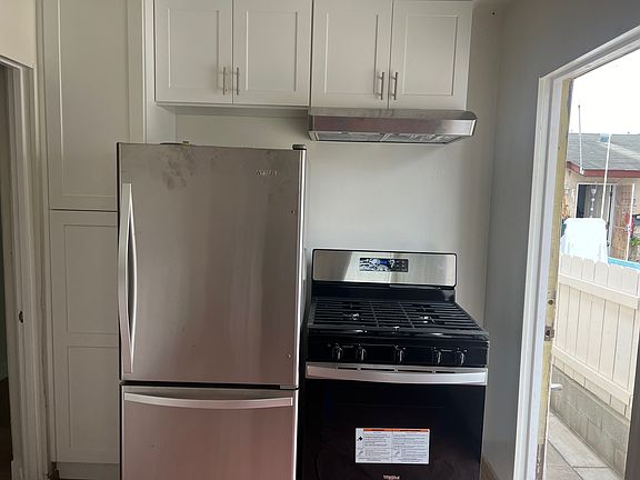 Remodeled Kitchen with brand new cabinets, countertops, sink, refrigerator, gas stove and ceiling fan