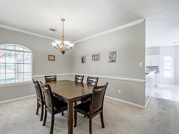 Natural light streams through this large dining room window that illuminating your largest table. The lovely 6 globe chandelier will create the perfect ambience for those late evening get togethers.