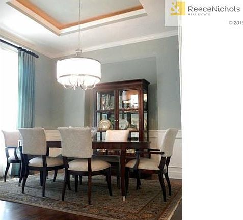 Formal dining room with trey lighted ceiling, gleaming wood floo