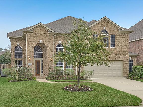 Welcome to 25210 Bristlecone Pine Lane in Auburn Lakes, Spring TX. The front view of the home shows the gorgeous two story windows with solar screens, two car garage, garage extension on right also has a window on front of home. Home is fully guttere