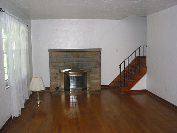 Living room with exposed hardwood floors.  Log burning fireplace.