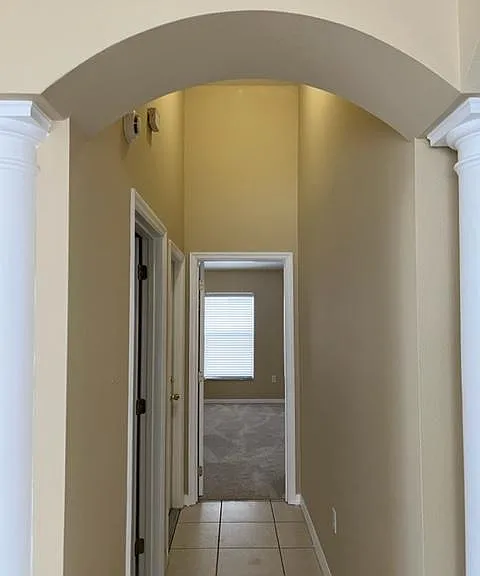 Hall from dining room towards Master Bedroom. On the left there are two doors, the first is to the Laundry room and the second door to the garage