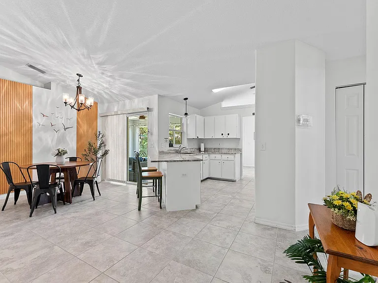 Open-concept kitchen and dining area with ample cabinetry, peninsula seating, and easy patio access for everyday meals.
