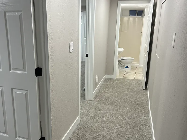 Hallway on lower level that leads to 2 bedrooms and 1 bathroom