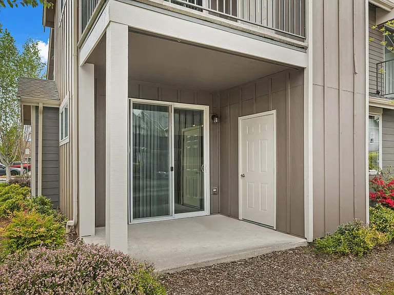 Private covered patio with sliding glass door and landscaped entry at Port Landing at Fife in Fife, WA. Private covered patio with sliding glass door and landscaped entry at Port Landing at Fife in Fife, WA.