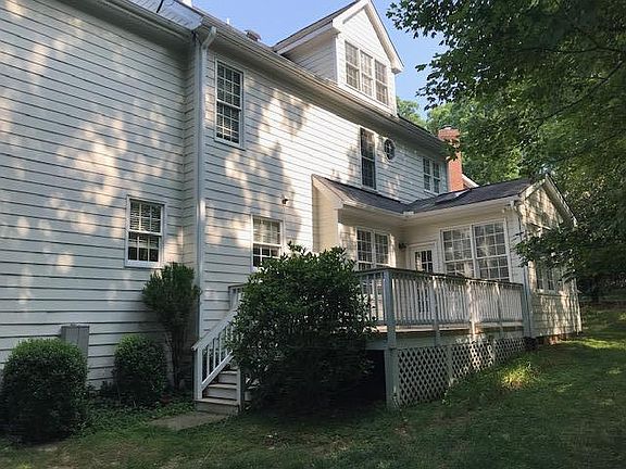 The back of the house showing large deck, and sun room off the back of the house.