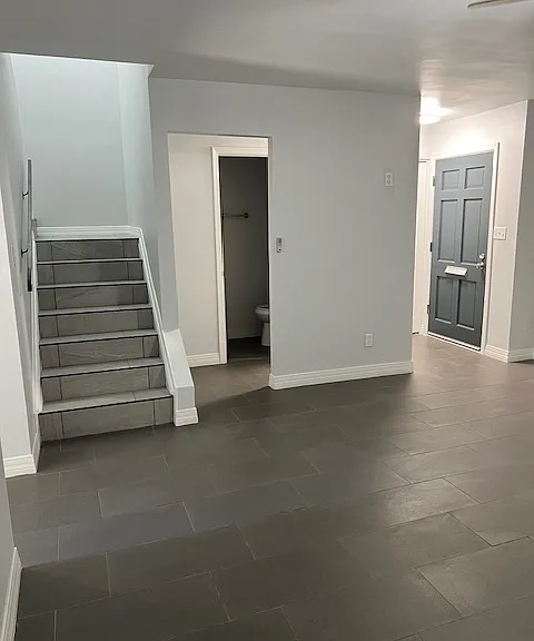 Living Room: Front Door Entry Way, Powder Bathroom, Tile and Grout Flooring, Freshly Painted Ceiling, Walls, Baseboards, Doors and Moldings, Ceiling Fan with Light, Stairwell Entry with Brand New Tile and Grout with Black Metal Accents, New Baseboard.