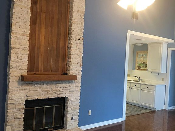 FIreplace in living room with view of the kitchen.