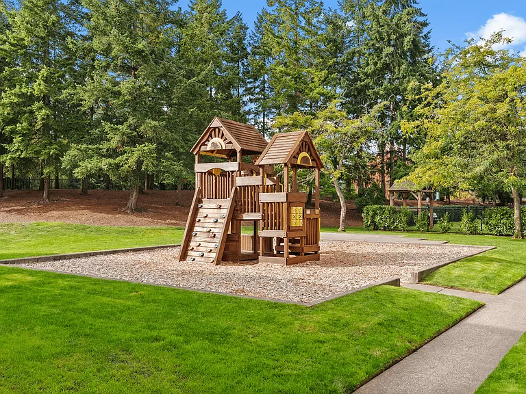 Playground surrounded by lush greenery.