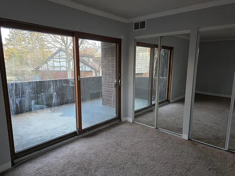 Master bedroom with a big mirror doors closet and door to the balcony.