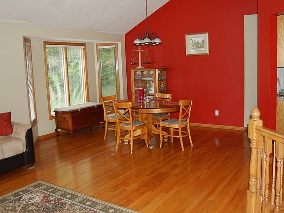 Living and dining rooms with large windows and vaulted ceiling.