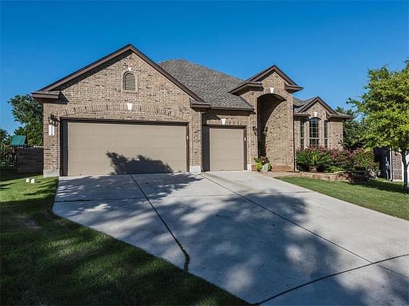 Three car garage is complete with ceiling mounted storage system to maximize storage space.