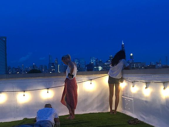 Private rooftop of 1847 W Grand with faux grass, patio furniture and lighting.
