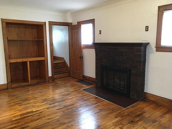 Living room shelves, fireplace, & stairway
