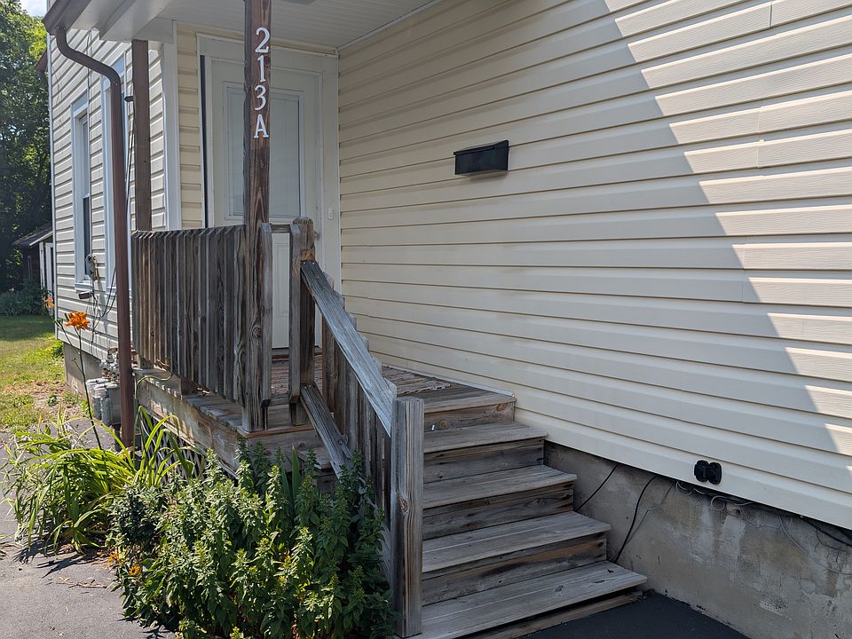 Exterior entrance with small porch. Black topped driveway for off street parking. Landscaped along porch.