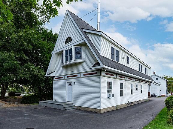 Two parking spots directly behind the building. Front door is on the left side of the building.