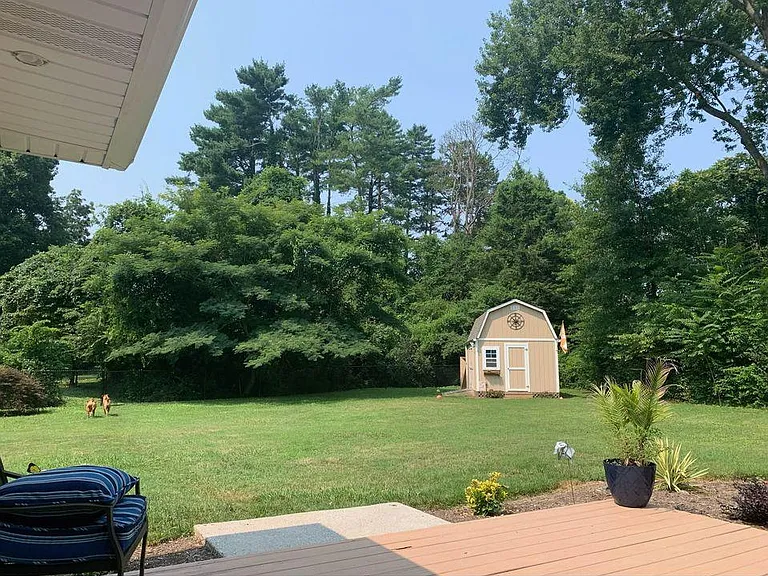 Fenced private yard with deck and storage barn