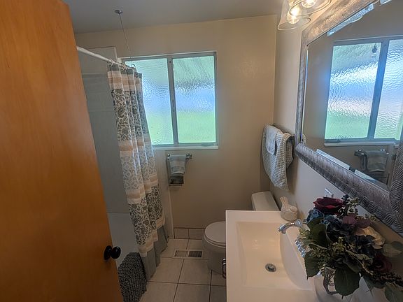 Full Bathroom with shower & tub, with white tile and a gray vanity.