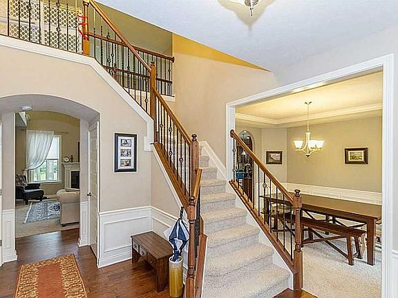 Entry. Stairs with wrought iron railing. Hardwood floors.