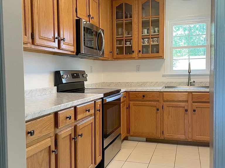 Bright open kitchen with ample counter space, cabinetry and stainless steel applicances.