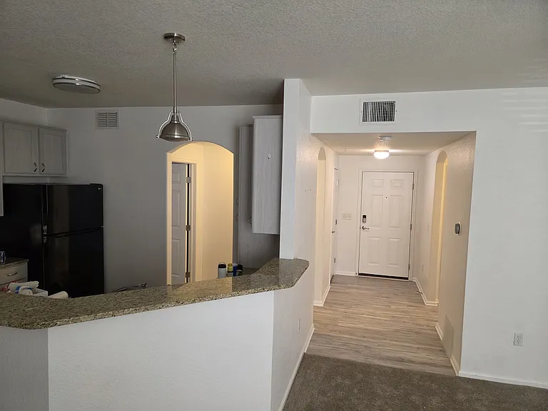 Entrance hall with closet- halls to kitchen, primary bath, bed and balcony, and the guest bath, washer/dryer and guest bedroom and balcony