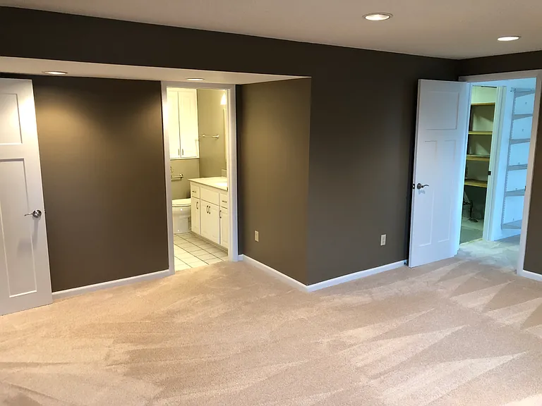 Primary room has ensuite half bathroom, walk-in closet, and access to utility and storage room.