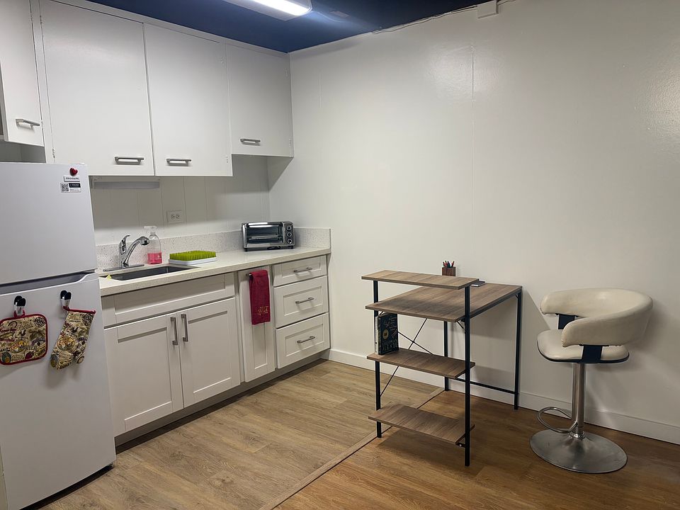 Writing desk and chair, overview of kitchen area and full size refrigerator