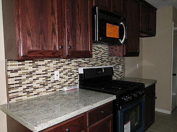 CLose up view of the granite counters and glass tile back splash.