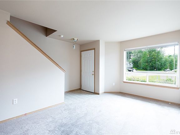 Front entry, with stairs going up to the bedrooms. Good sized living room with natural light coming in.