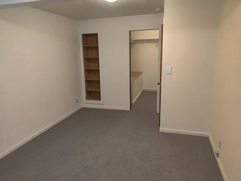 Master bedroom angle showing in-wall storage and walk-in closet