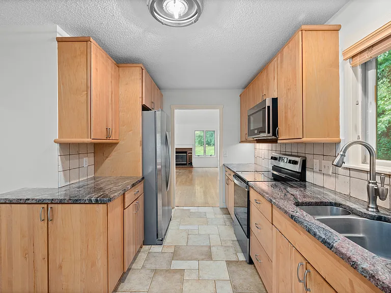 Walkthrough Kitchen with stainless steel appliances, cabinet underlighting, plenty of counter and cabinet space