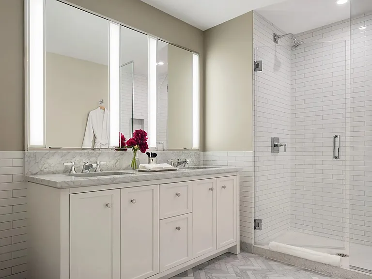 Luxuriate in master baths featuring white natural stone vanity, Kohler fixtures and accessories in p