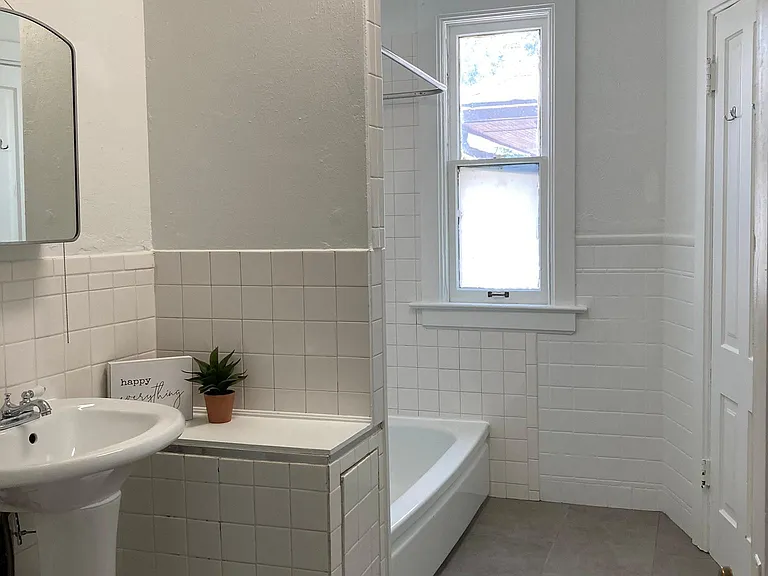 White, bright bathroom with full closet.