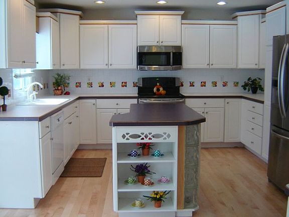 This light and bright kitchen is warm and welcoming. The work counter helps make meal preparation a breeze and the open shelves are great for recipe books or a place to display favorite nick knacks. You will love the gleaming hardwood floors and backsplash tile.