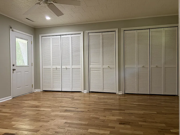 Spacious primary bedroom featuring beautiful hardwood floors, generous closet space, and direct access to the private en-suite bathroom.
