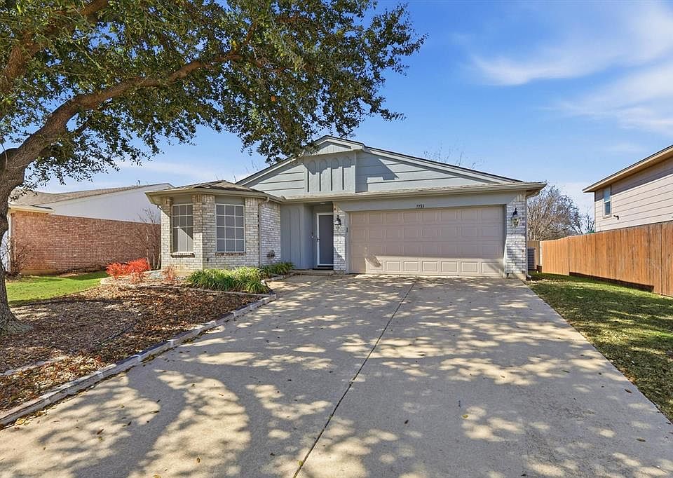 Ranch-style home with a garage, concrete driveway, and brick siding