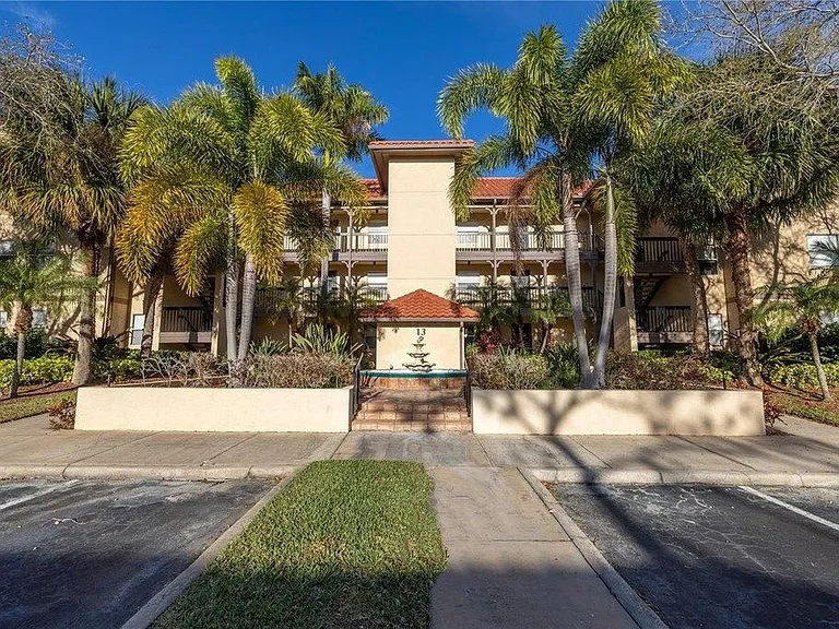 One of the designated parking spots is located to the right of the sidewalk directly out front of the building.