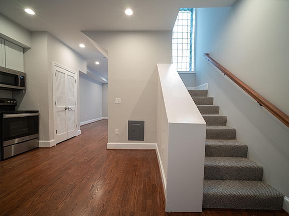 Eat-in kitchen with view of living area beyond and stairs to bedroom and bathroom.