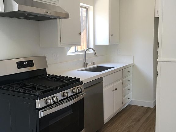 kitchen with new appliances , countertop, sink, faucet and cabinet