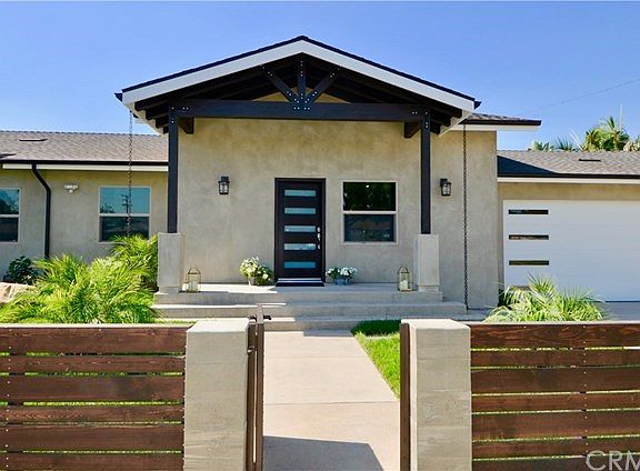 THE LARGE COVERED FRONT PORCH WITH WOOD BEAMS IS AN ELEGANT STATEMENT OF WHAT AWAITS.